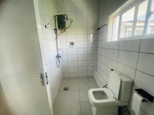 a white bathroom with a toilet and a window at Nyali one bedroom Villa- Subree Luxury in Mombasa