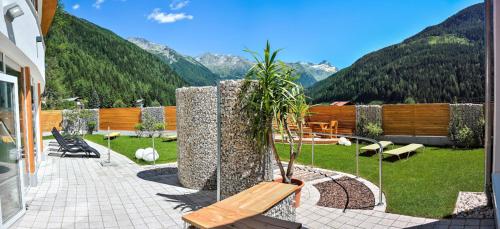 a bench on a patio with mountains in the background at Ankogel Lofts Mallnitz in Mallnitz