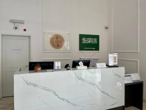 a white marble counter in a room with signs on it at Cent Al Azizia Hotel Makkah in Makkah