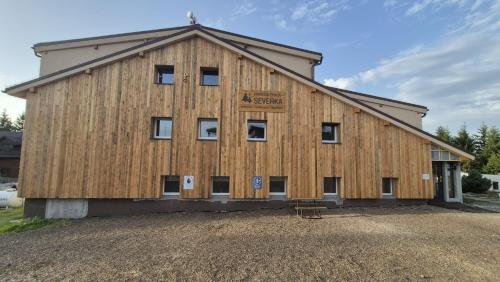 a large wooden barn with a sign on it at Horská chata Severka in Dolní Lomná