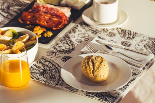 een ontbijttafel met een bord eten en jus d'orange bij La Casona de Yaiza I Hotel Emblematico in Yaiza