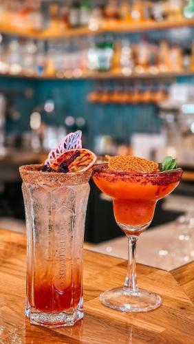 two cocktails sitting on top of a wooden table at Le Lodge des Îles d'Or in Hyères