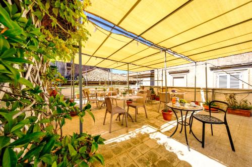 a patio with tables and chairs under a yellow tent at Al Seminario in Tivoli