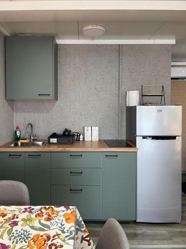 a kitchen with a white refrigerator and a counter at Altair House 