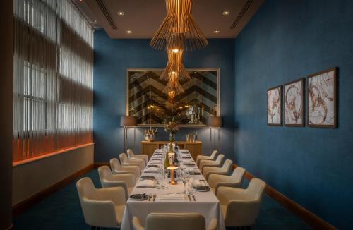 a dining room with a long table and white chairs at Clayton Hotel Birmingham in Birmingham