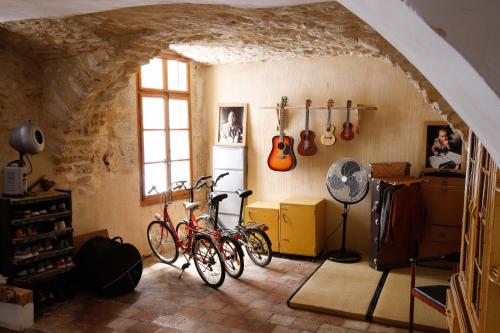 two bikes in a room with guitars on the wall at Appartement villageois ou maison entière in Aniane