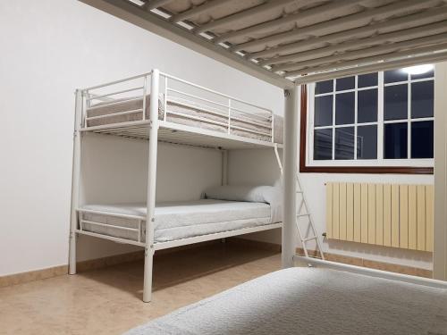 a white bunk bed in a room with a window at Casa Esmeralda in Borbén