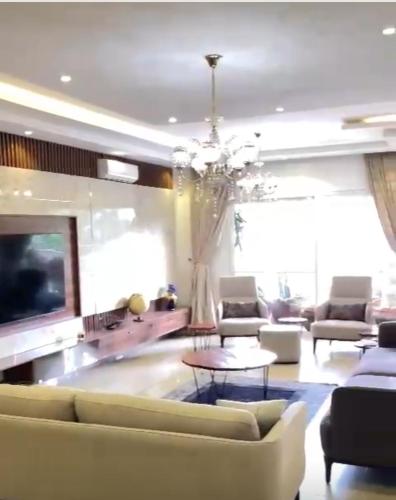 a living room with a couch and a tv and a chandelier at Elite Luxury Apartment in Lagos
