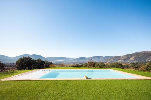 ein Swimmingpool auf einem Feld mit Bergen im Hintergrund in der Unterkunft Chambre d'hôtes avec jacuzzi proche Saint Tropez in Plan-de-la-Tour