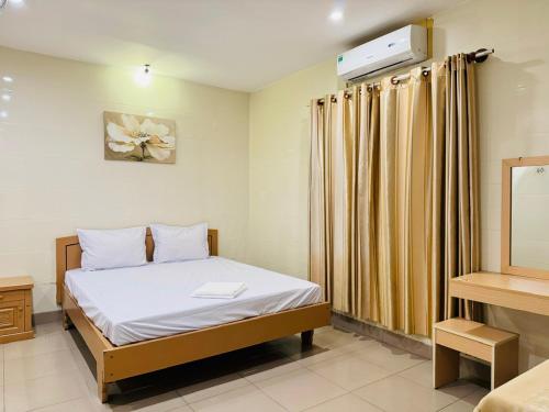 a small bedroom with a bed and a mirror at Motel Mốt in Danang