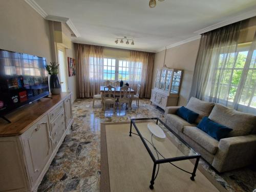a living room with a couch and a tv at Casa en la playa de Panxón in Nigrán