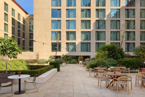 a courtyard with tables and chairs in front of a building at ME Barcelona in Barcelona