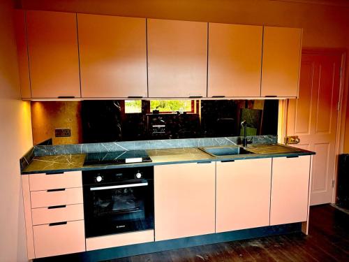 a kitchen with white cabinets and a stove top oven at Poole Quay Apartment - Perfect Location - Beatiful Roof Terrace - Free Parking in Poole