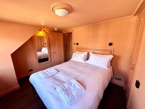 a bedroom with a large bed with white sheets at Poole Quay Apartment - Perfect Location - Beatiful Roof Terrace - Free Parking in Poole