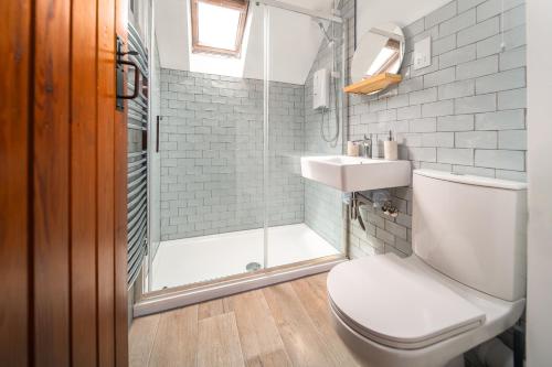 a bathroom with a shower and a toilet and a sink at Poppy Cottage - river view, dog friendly in Whitby