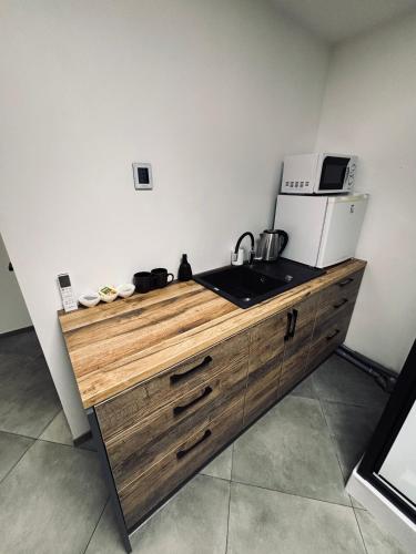 a kitchen with a sink and a microwave on a counter at 69 apartaments II in Panevėžys