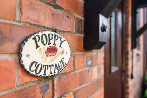 a sign on the side of a brick wall at Poppy Cottage - river view, dog friendly in Whitby