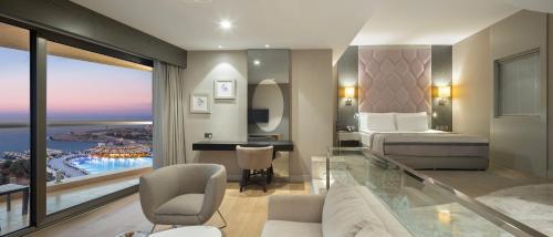 a hotel room with a bed and a view of the ocean at Elexus Hotel Resort & Spa & Casino in Kérynia