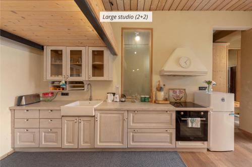 Una cocina con gabinetes blancos y un refrigerador blanco. en IQ wood apartment, en Liubliana