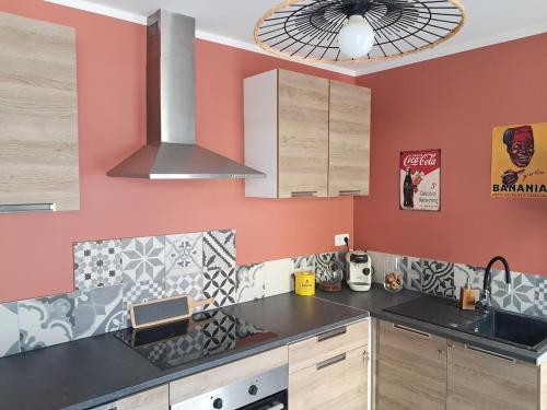 a kitchen with red walls and a stove top oven at Templemars proximité Lille 4 personnes jardin in Templemars