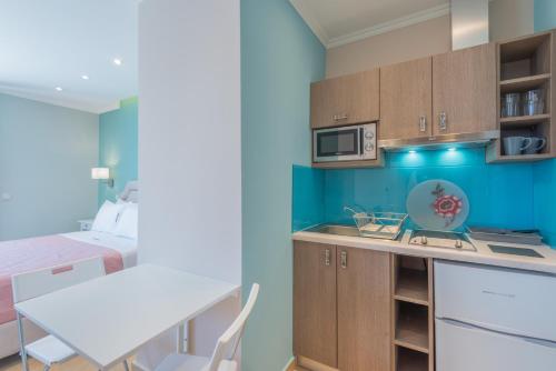 a small kitchen with a table and a bed at Pansion Ermioni in Skala