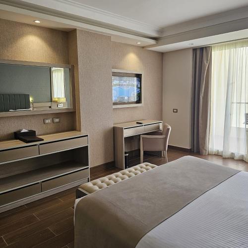 a hotel room with a bed and a desk and a television at Xanadu Makadi Bay - High Class All Inclusive in Hurghada