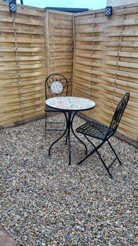 a table and a chair in front of a fence at The Creamery High Harrington in Harrington