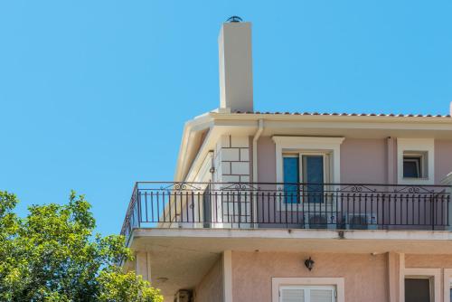 a building with a balcony and a lighthouse on top at Pansion Ermioni in Skala
