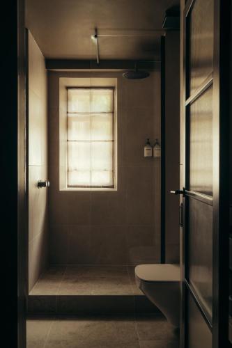 a bathroom with a shower and a toilet and a window at Hyll Hotel in Chipping Campden