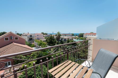 a balcony with a bench and a view of the city at Pansion Ermioni in Skala
