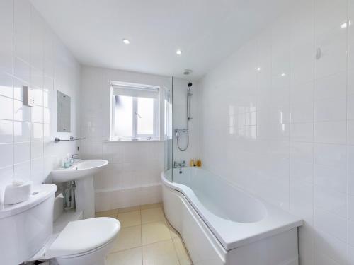 Un baño blanco con bañera, inodoro y lavabo. en Bright 2 Bedroom Apartments in Marston, Near John Radcliffe Hospital & University Parks, en Oxford