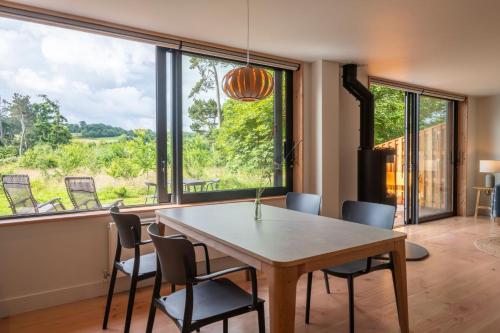 Un comedor con mesa y sillas y una gran ventana. en Amberwood Lodge, en Hay-on-Wye