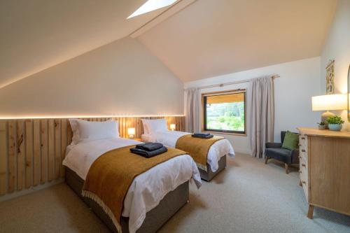 Una habitación de hotel con dos camas y una ventana. en Amberwood Lodge, en Hay-on-Wye