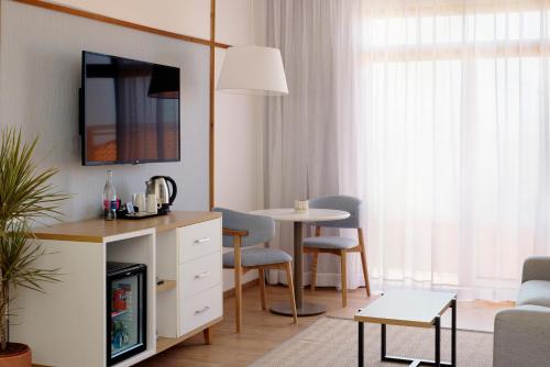 a living room with a table and chairs and a room at Melia Jardines del Teide - Adults Only in Adeje