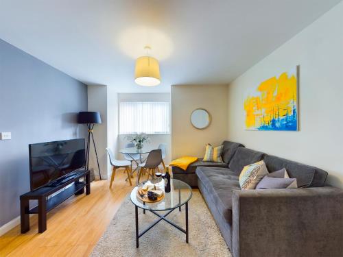a living room with a couch and a table at Bright 2 Bed Apartments in Marston Oxford, Free Parking, OX3 Near John Radcliffe Hospitals & University Parks in Oxford