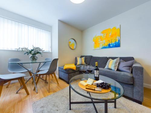a living room with a couch and a table at Bright 2 Bed Apartments in Marston Oxford, Free Parking, OX3 Near John Radcliffe Hospitals & University Parks in Oxford