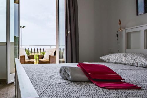 a bedroom with a large bed with red towels on it at Villa il Faro in Siracusa