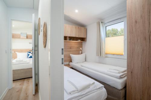 a small room with two beds and a window at Ostseecamp Küstenkind, eingezäuntes Grundstück in Scharbeutz