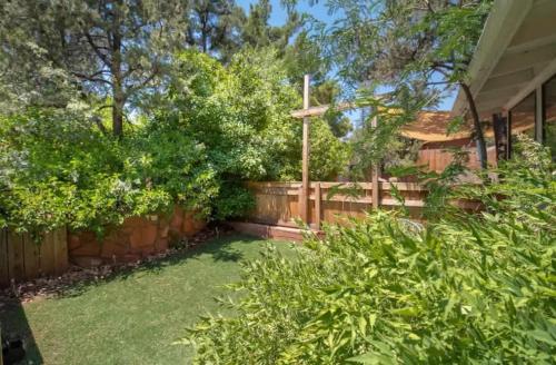 a backyard with a wooden fence and a cross at Red Rock Retreat with Amazing Patio and Hot Tub for family in Sedona