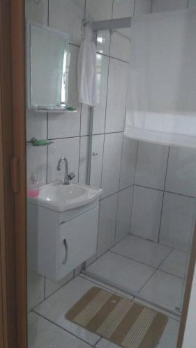 a white bathroom with a sink and a mirror at Hotel Santa Thereza in Bofete
