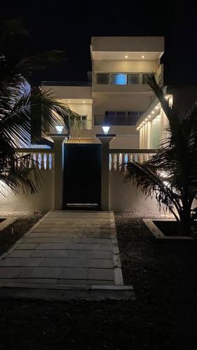 a house at night with a door and a palm tree at شالية ماربيا الاشخرة Marbella Ashkhara Chalet in Al Ashkharah