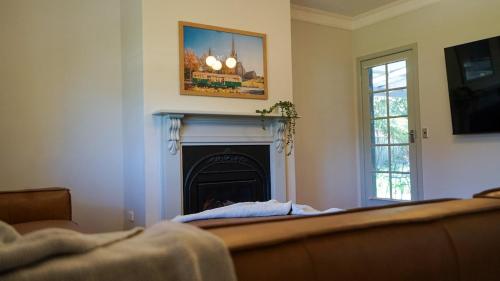 a living room with a fireplace and a couch at The Conductors Quarters in Bendigo