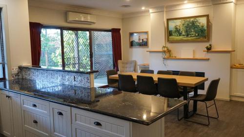 a kitchen with a table and chairs in a room at The Conductors Quarters in Bendigo