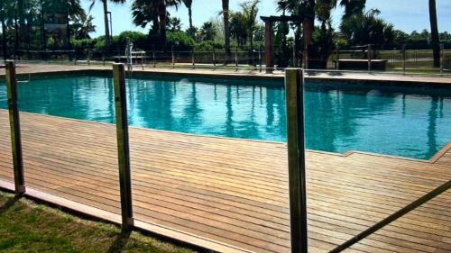 a large swimming pool with a wooden deck at LM APARTAMENTOS Dos mares in Motril