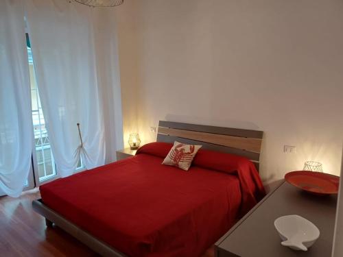 a bedroom with a red bed with a red blanket at Casa Sirio -Rapallo in Rapallo