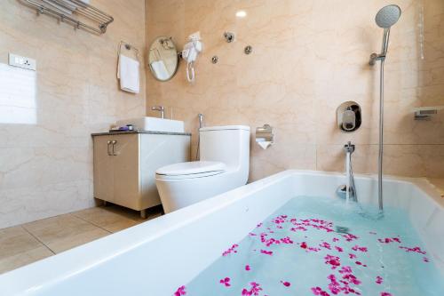 a bathroom with a bath tub with a toilet and a bath tub at Triple Crown Resort in Dhāding