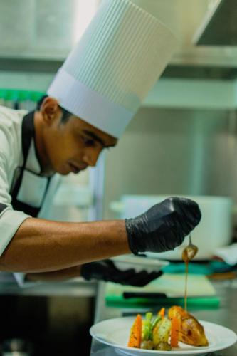 a chef in a kitchen preparing a plate of food at Marine Suites in Colombo