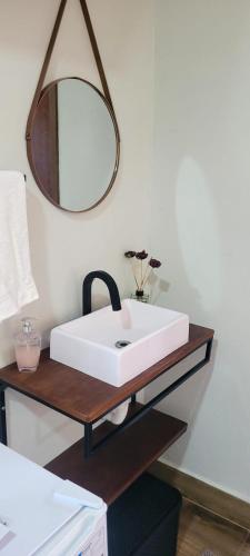a bathroom with a white sink and a mirror at POUSADA Chacara ENTRE NÓS in Holambra