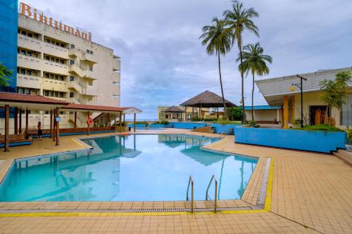 a swimming pool at a hotel with palm trees at Bintumani in Freetown