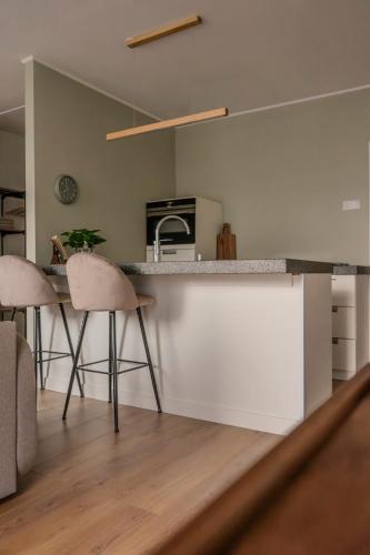 a kitchen with a counter and stools in a room at City apartment in the centre of Enschede in Enschede